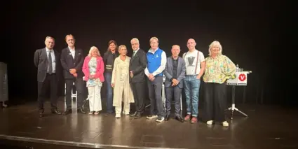 En grupp politiker som står uppe på en scen.