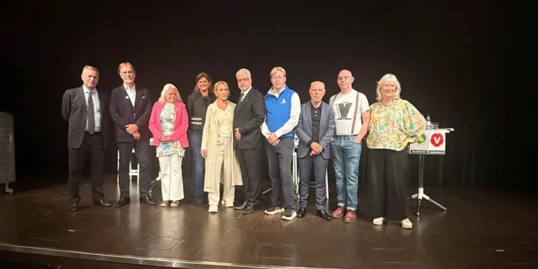 En grupp politiker som står uppe på en scen.