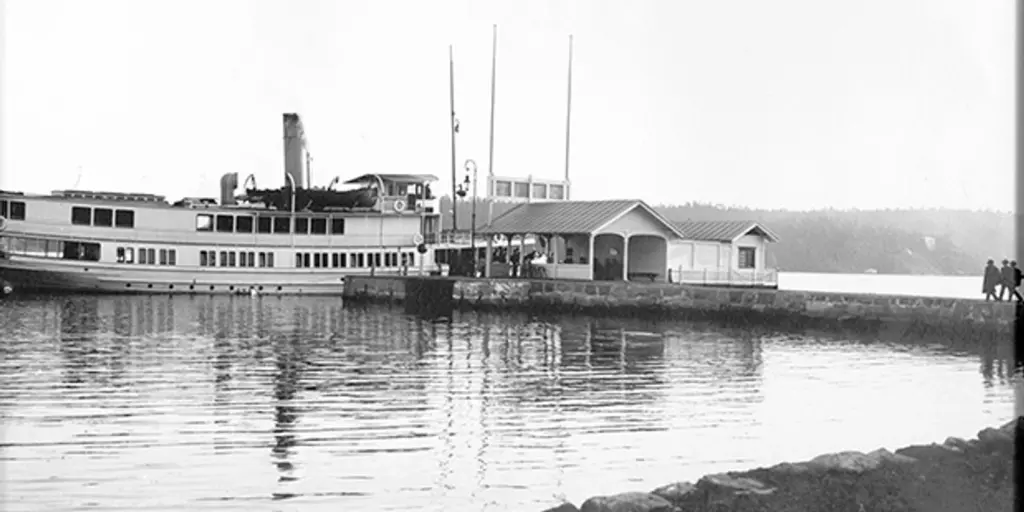 Ett svartvitt foto av en ångbåt vid en brygga.