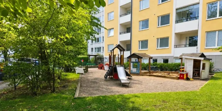 En lekplats framför ett flervåningshus.