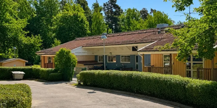 Ett hus med en uppfart omgiven av häckar.