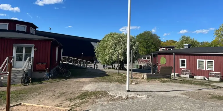 En röd byggnad med en flaggstång framför sig.