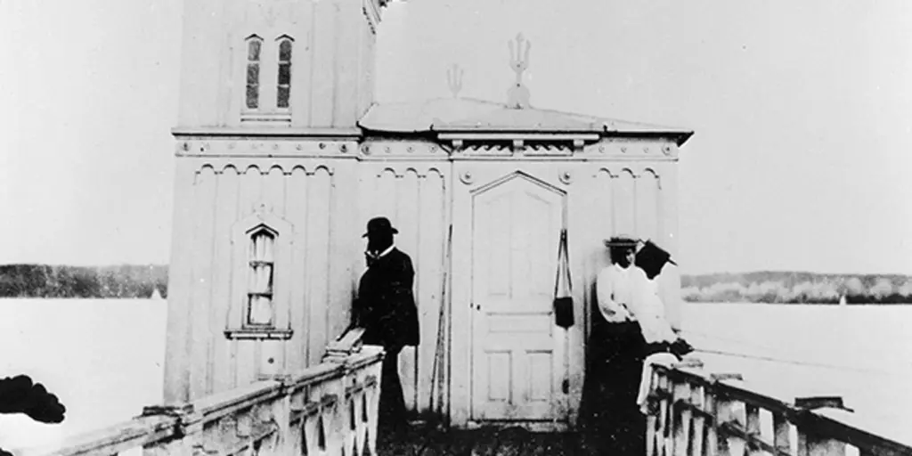Ett svartvitt foto av en man och två kvinnor vid ett badhus. 