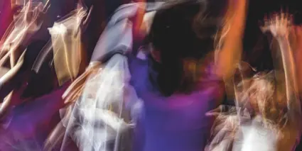 Ett suddigt foto av en grupp människor som dansar.