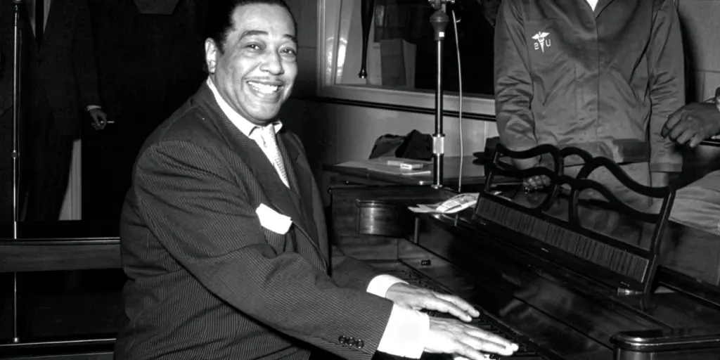 Duke Ellington sitter vid ett piano.