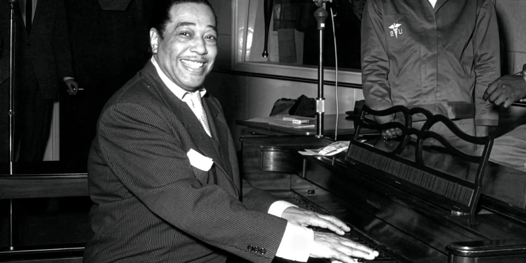 Duke Ellington sitter vid ett piano.