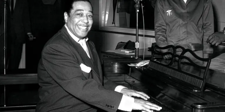 Duke Ellington sitter vid ett piano.